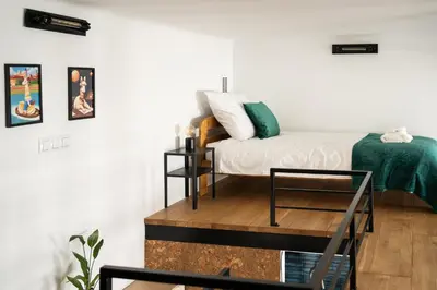 a bedroom with a bed and a table at Luxe Living Kazimierz with Patio in Kraków