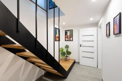 a staircase in a house with black and white walls at Luxe Living Kazimierz with Patio in Kraków