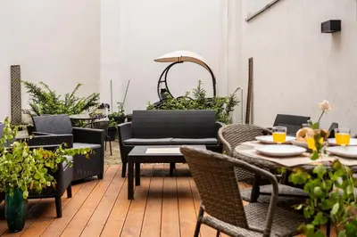 an outdoor patio with tables and chairs and plants at Luxe Living Kazimierz with Patio in Kraków