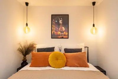 a bedroom with a bed with orange pillows at Luxe Living Kazimierz with Patio in Kraków