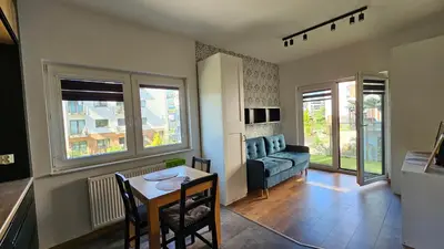 a living room with a couch and a table at Apartment Bunscha Park in Kraków