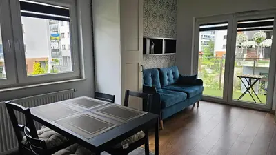 a living room with a blue couch and a table at Apartment Bunscha Park in Kraków
