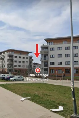 a building with a red arrow in front of it at Apartment Bunscha Park in Kraków