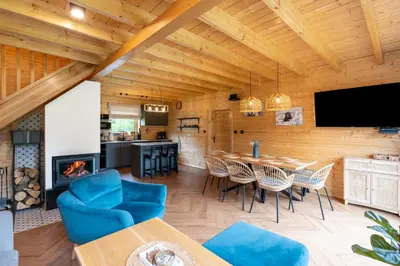 a living room with a table and chairs and a fireplace at Wilczna Stodoła in Zawoja