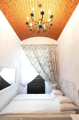 a bedroom with a bed with a yellow ceiling at Apartamenty Winnicy Kresy III in Kraków