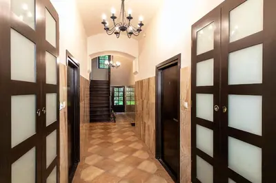 a hallway with doors and a chandelier at Apartamenty Winnicy Kresy III in Kraków