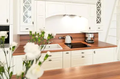 a kitchen with white cabinets and a sink at Apartamenty Winnicy Kresy III in Kraków