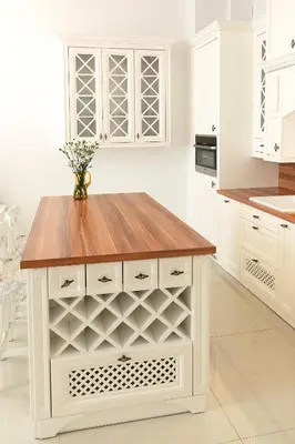 a kitchen with white cabinets and a wooden counter top at Apartamenty Winnicy Kresy III in Kraków