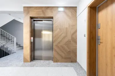 an elevator in a building with a wooden wall at Czerwone Maki Studio with Garden by BookingHost in Kraków