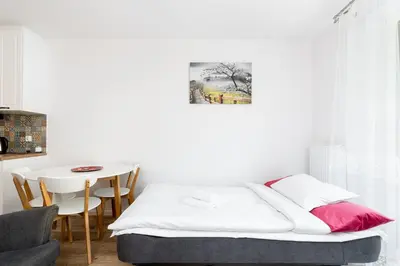 a small bedroom with a bed and a table at Czerwone Maki Apartment with Garden by BookingHost in Kraków