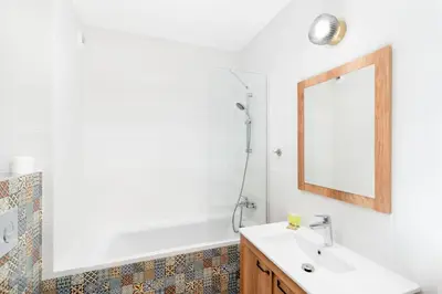 a bathroom with a sink and a mirror at Czerwone Maki Apartment with Garden by BookingHost in Kraków