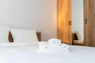 a stack of towels sitting on top of a bed at Czerwone Maki Apartment with Garden by BookingHost in Kraków