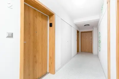 an empty corridor with wooden doors in a building at Czerwone Maki Apartment with Garden by BookingHost in Kraków