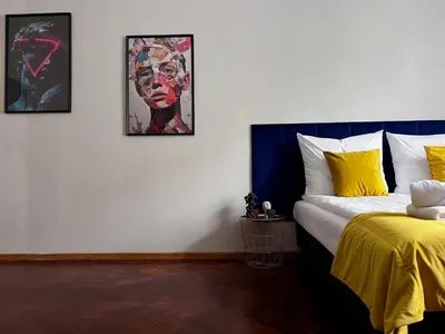 a bedroom with a bed and three pictures on the wall at GA Apartments in Kraków