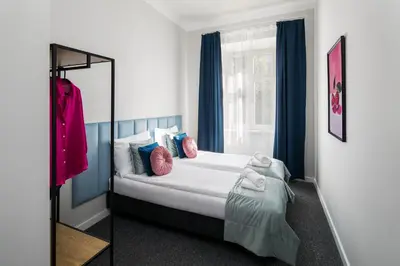 a bedroom with a bed with pillows and a window at GA Apartments in Kraków