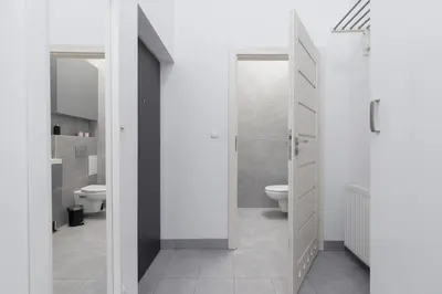 a white bathroom with a toilet and a sink at 3 Bedroom Apartment - Rynek Podgórski 15 in Kraków