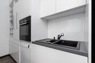 a white kitchen with a sink and a microwave at 3 Bedroom Apartment - Rynek Podgórski 15 in Kraków
