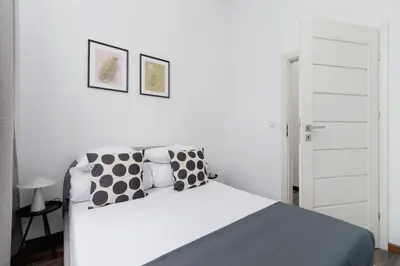 a bedroom with a bed with black and white pillows at 3 Bedroom Apartment - Rynek Podgórski 15 in Kraków