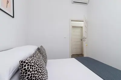 a bedroom with a white bed with a leopard print pillow at 3 Bedroom Apartment - Rynek Podgórski 15 in Kraków