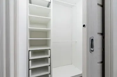 a closet with white shelves next to a door at 3 Bedroom Apartment - Rynek Podgórski 15 in Kraków