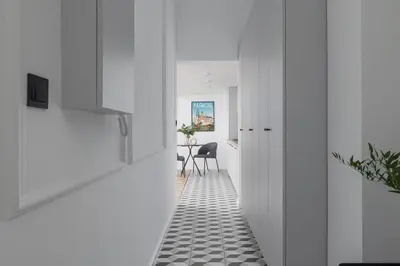 a hallway with white walls and a black and white tile floor at Kazimierz - Apartment with Balcony - Starowiślna 41 in Kraków