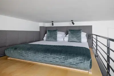 a bedroom with a large bed with a green blanket at Kazimierz - Apartment with Balcony - Starowiślna 41 in Kraków