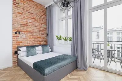 a bedroom with a bed and a brick wall at Apartment with Balcony - Kazimierz- Starowiślna 41 in Kraków