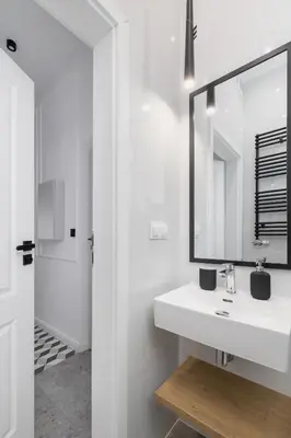 a white bathroom with a sink and a mirror at Apartment with Balcony - Kazimierz- Starowiślna 41 in Kraków