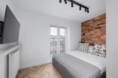 a bedroom with a bed and a brick wall at Studio in Kazimierz District - AC - Starowislna 41 in Kraków