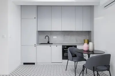 a kitchen with white cabinets and a table and chairs at Studio in Kazimierz District - AC - Starowislna 41 in Kraków