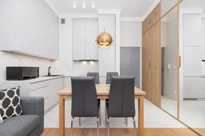 a kitchen and dining room with a wooden table and chairs at 1 bedroom apartment - Kazimierz- Starowislna 43 in Kraków