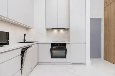 a white kitchen with white cabinets and appliances at 1 bedroom apartment - Kazimierz- Starowislna 43 in Kraków