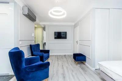 a room with two blue chairs and a bed at Premium Glamour Apartment by Krakow Home in Kraków