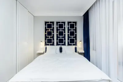 a bedroom with a white bed and two windows at Premium Glamour Apartment by Krakow Home in Kraków