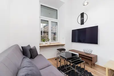a living room with a couch and a tv at Apartment with mezzanine - Radziwiłłowska 27 in Kraków