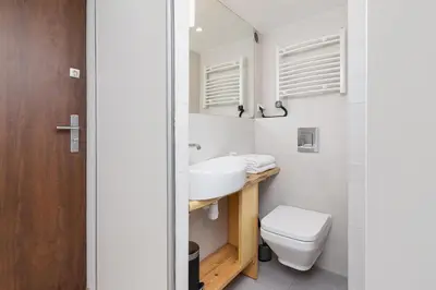 a bathroom with a white toilet and a sink at Apartment with mezzanine - Radziwiłłowska 27 in Kraków