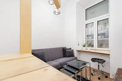a living room with a couch and a table at Apartment with mezzanine - Radziwiłłowska 27 in Kraków