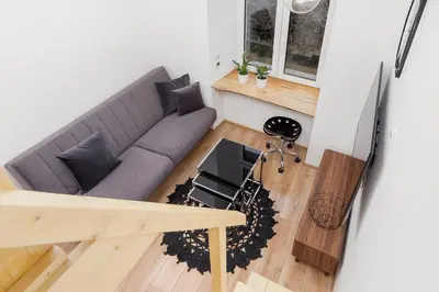 a living room with a couch and a table at Apartment with mezzanine - Radziwiłłowska 27 in Kraków
