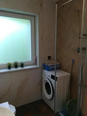 a bathroom with a washing machine and a window at Apartamencik Pod Krokusem in Rabka-Zdroj