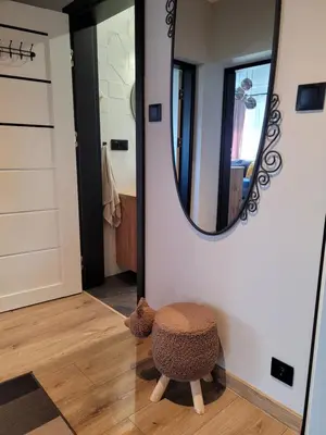 a ottoman sitting in a hallway with a mirror at Apartamencik Pod Krokusem in Rabka-Zdroj