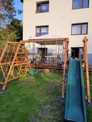 a playground in front of a house with a slide at Apartamencik Pod Krokusem in Rabka-Zdroj