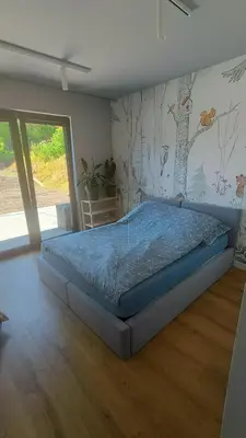 a bedroom with a bed with a tree mural on the wall at Luksusowy dom z basenem blisko Energylandii, Krakowa i Oświęcimia in Trzebinia