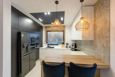 a kitchen with a wooden table and blue chairs at Luksusowy dom z basenem blisko Energylandii, Krakowa i Oświęcimia in Trzebinia