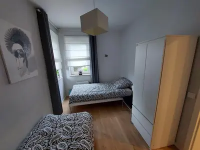 a small room with a bed and a mirror at Place4You in Kraków