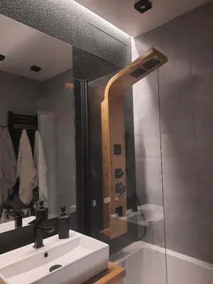 a bathroom with a white sink and a shower at Place4You in Kraków