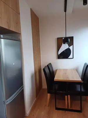 a dining room with a table and a refrigerator at Place4You in Kraków