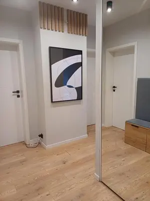 a room with a painting on the wall and a mirror at Place4You in Kraków