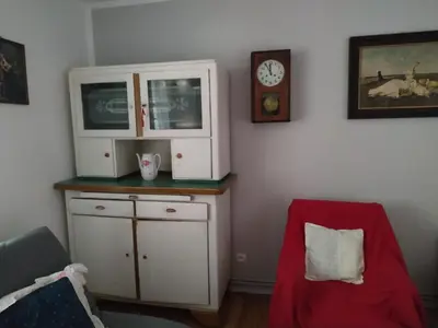 a room with a cabinet and a clock and a chair at Dom pod Galazka in Bochnia