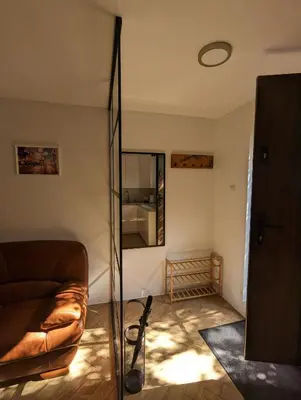 a living room with a couch and a mirror at Highstreet in Kraków