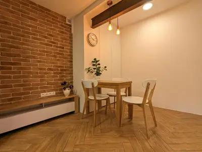 a dining room with a table and chairs and a brick wall at Highstreet in Kraków